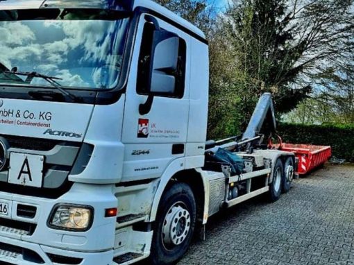 Lkw des Containerdienstes mit rotem Absetzcontainer